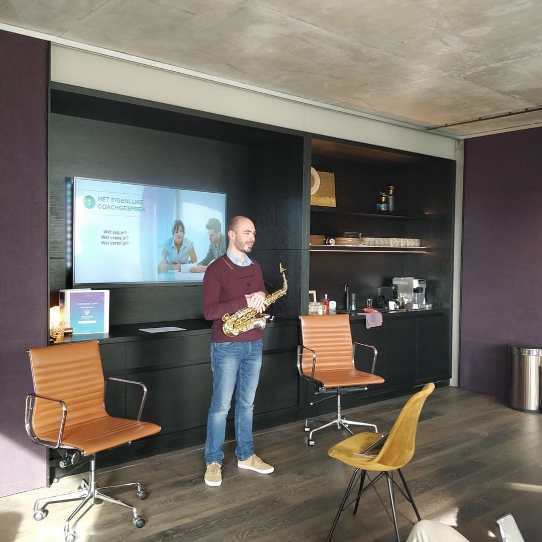 Kleurenfoto van mental coach Jeroen Vanbever met glimlach tijdens een presentatie