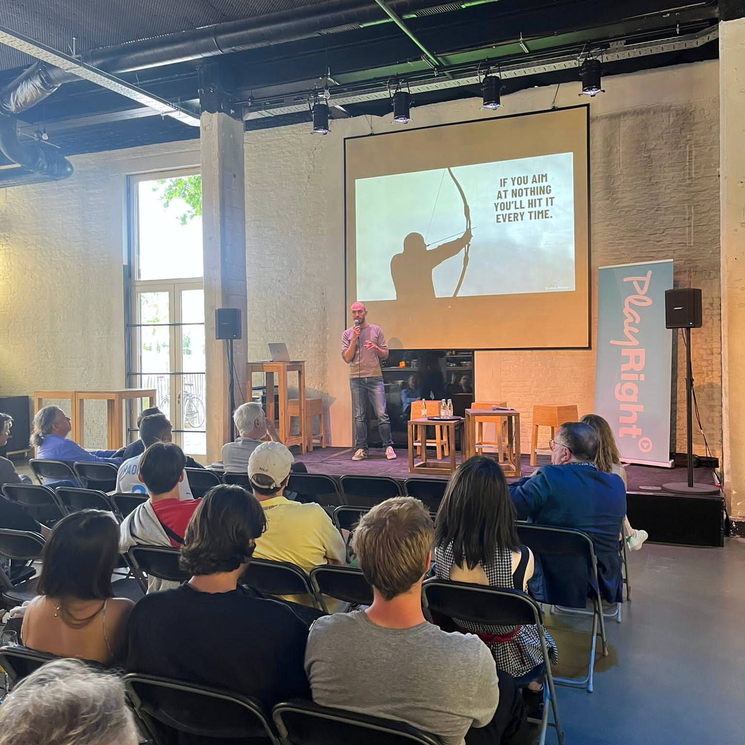 Kleurenfoto van mental coach Jeroen Vanbever met glimlach tijdens een presentatie