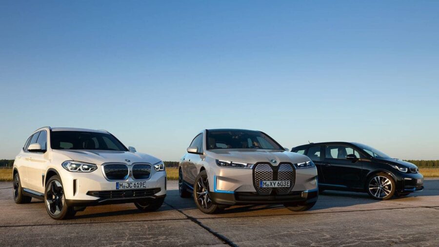 Tre elbiler er parkeret på en landingsbane under en klar blå himmel. Fra venstre mod højre: en hvid, en sølvfarvet og en sort bil, der viser moderne design.