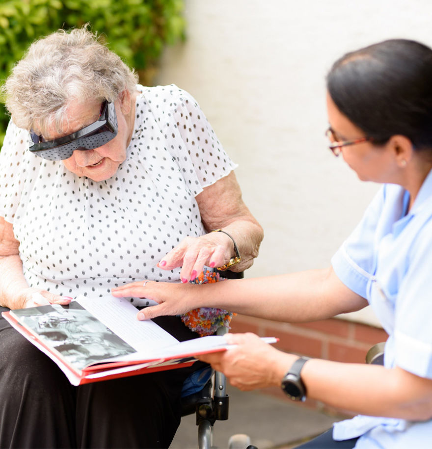 team member with elderly lady looking through book