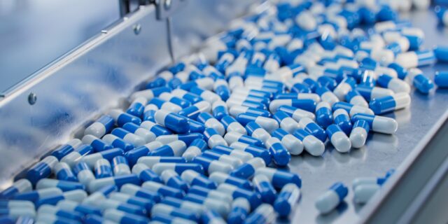 Blue,Capsules,Are,Moving,On,Conveyor,At,Modern,Pharmaceutical,Factory.