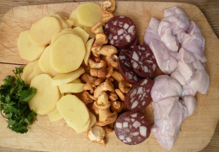 Petersilie, Kartoffelscheiben, Pfifferlinge, Blutwurst und Kalbsbries