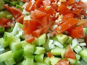 Tomate, Gurke, Zwiebel und Knoblauch kleinschneiden