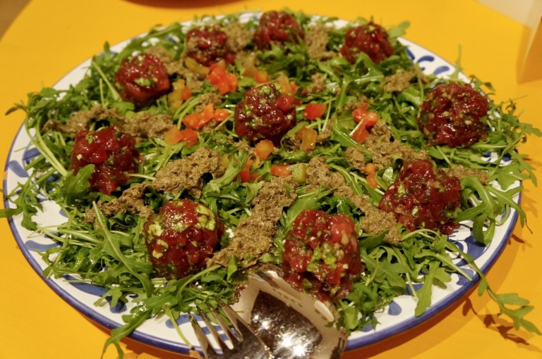 Crudo di pesce: Bällchen von Thunfisch und Garnelen auf Ruccola mit Sardellenpaste