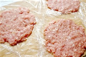 Fleisch portionsweise auf der Frischhaltefolie flachdrücken