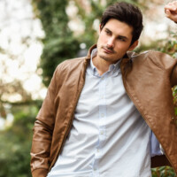 Portrait of a young handsome man, model of fashion, with modern hairstyle in urban background, wearing casual clothes.