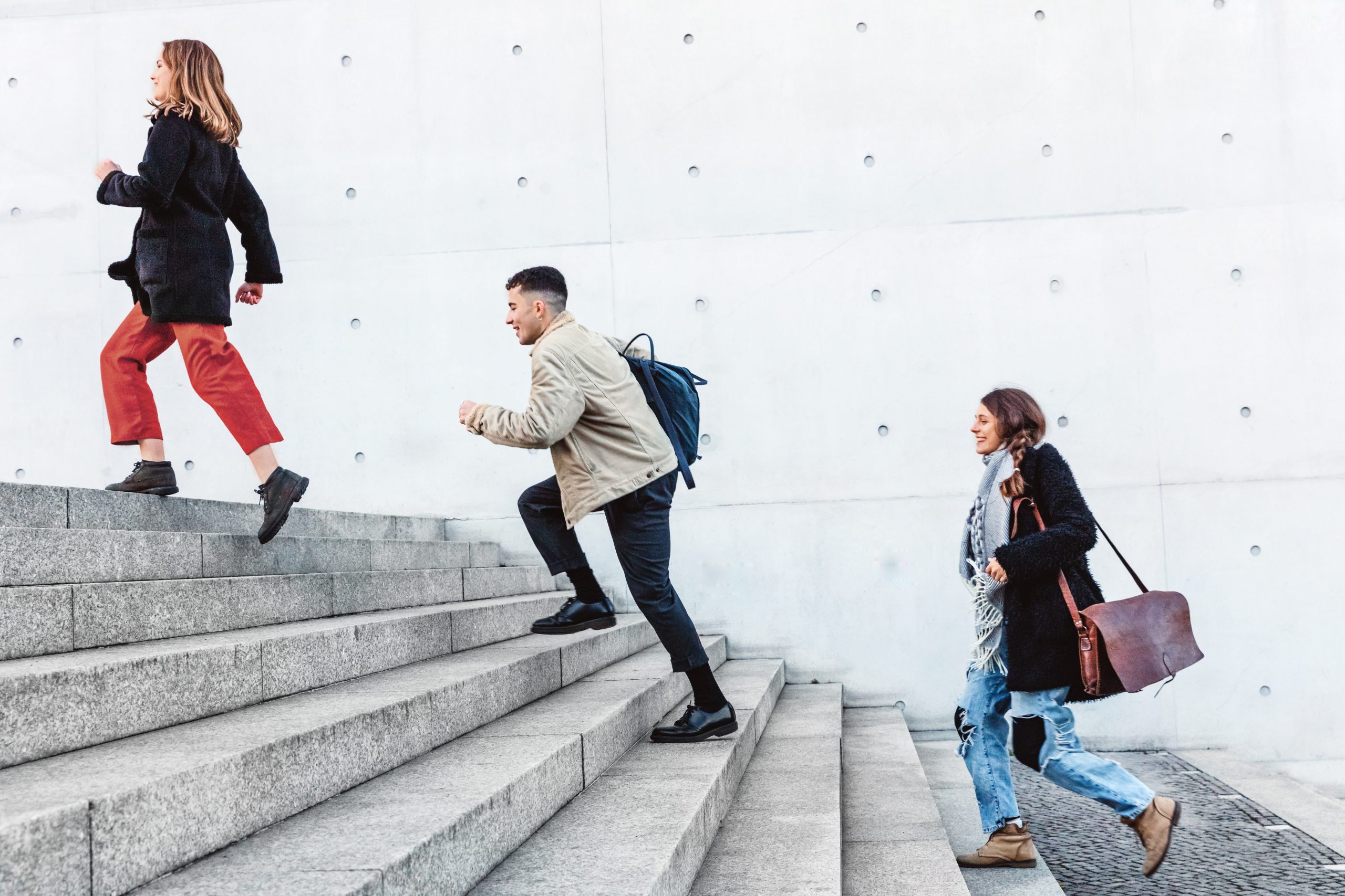 friends running up steps in urban setting