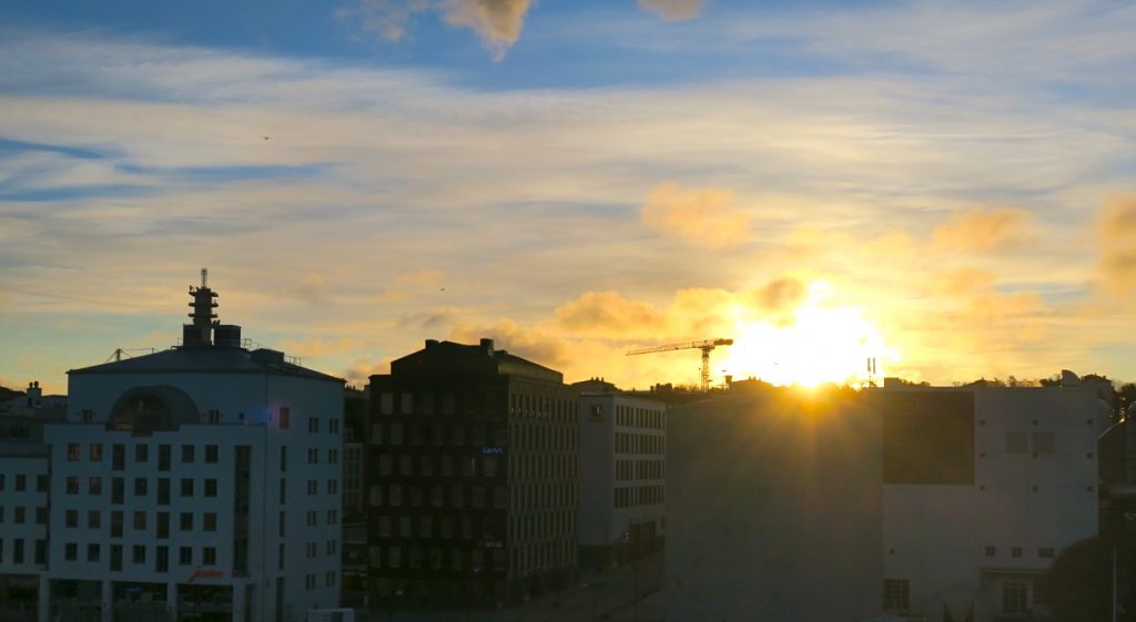 Solen på väg upp i södra Hammarbyhamnen. 