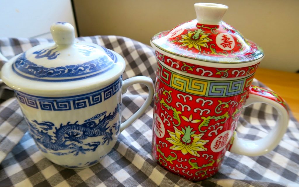 En kinesisk mugg för te är praktisk och har lock för att behålla värmen och en lös tesil-