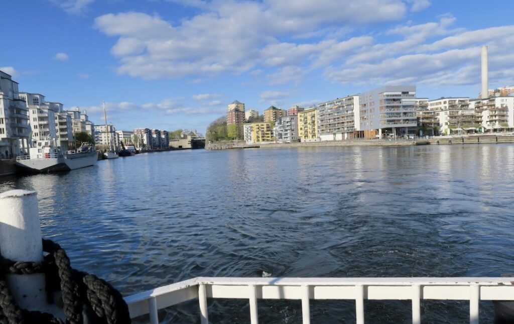 Stockholm. På väg till Henriksdalsbryggan och i blått sällskap. Blå himmel med lätta vita moln och även vattnet i Hammarby sjö ser blått ut. 