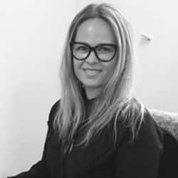 a woman wearing glasses and smiling