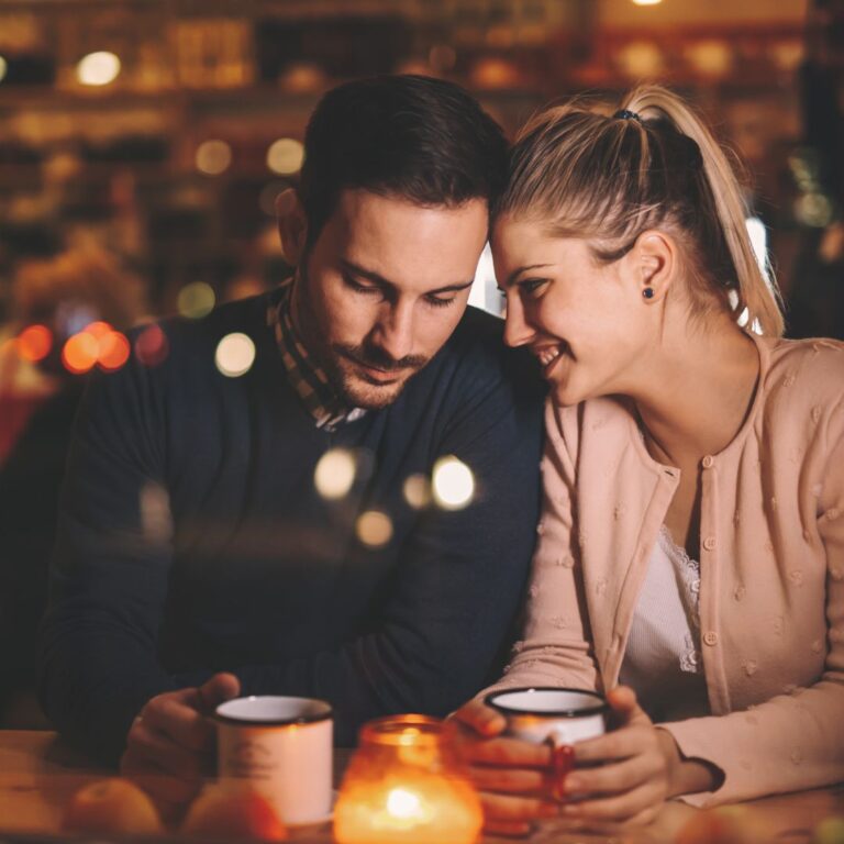 En man och kvinna på tredje dejten i en finare restaurang med mysig belysning och romantisk aura.