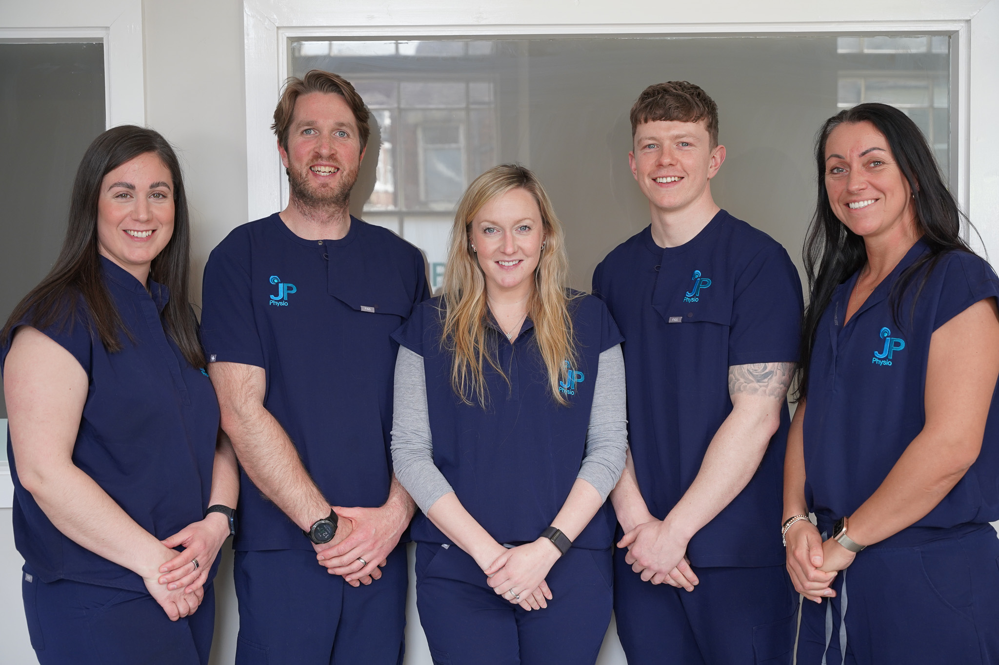Photo of five people in navy uniforms from JP Physio in Durham.