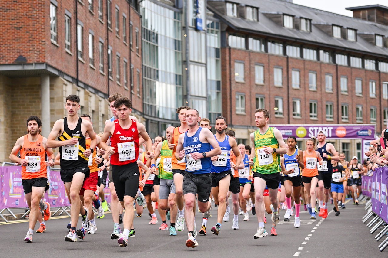 Thousands of runners crossing the start line at Durham City Runs.