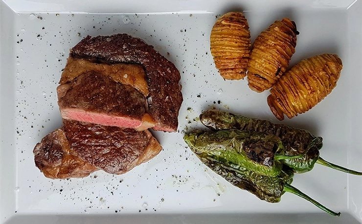 edles-fleisch-rezepte-paul-cooks-lento-ribeye-hasselback-kartoffeln-pimientos-de-padron-angerichtet