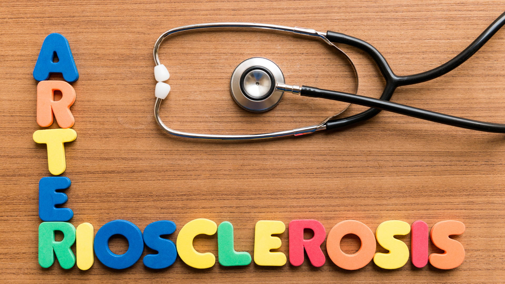 Fargerike bokstaver som staver ordet "arteriosclerosis" ved siden av et stetoskop på et trebord – illustrasjon av hjerte- og karsykdom