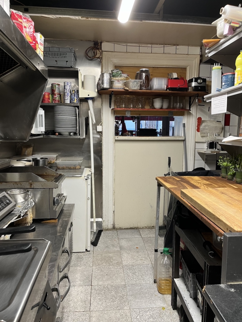 Vy från köket genom serveringsluckan – Smidig logistik mellan kök och matsal på La Trattoria, Östra Tullgatan.