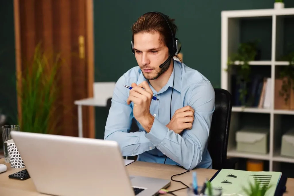 Homme avec casque en visioconférence dans un bureau