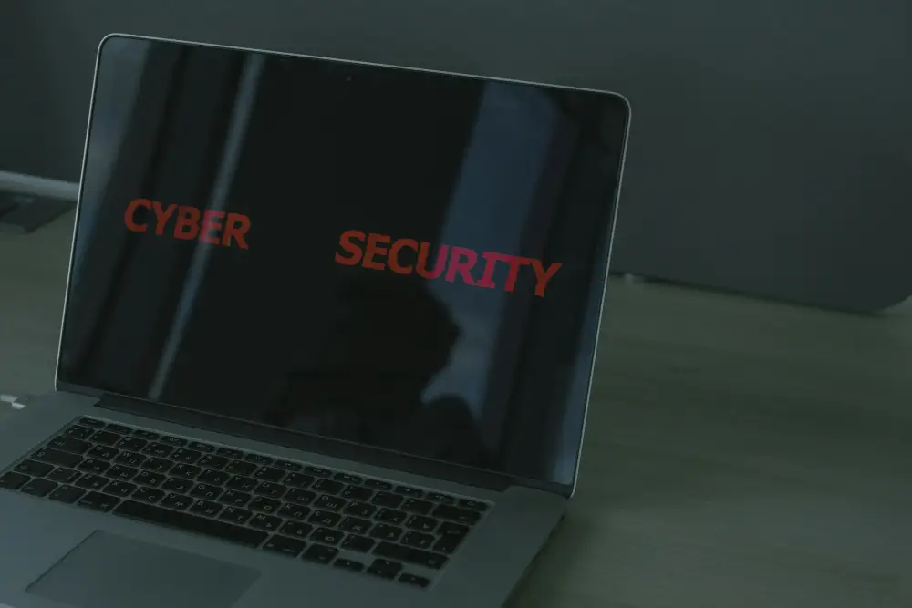 Ordinateur portable affichant les mots 'Cyber Security' en rouge sur un écran sombre