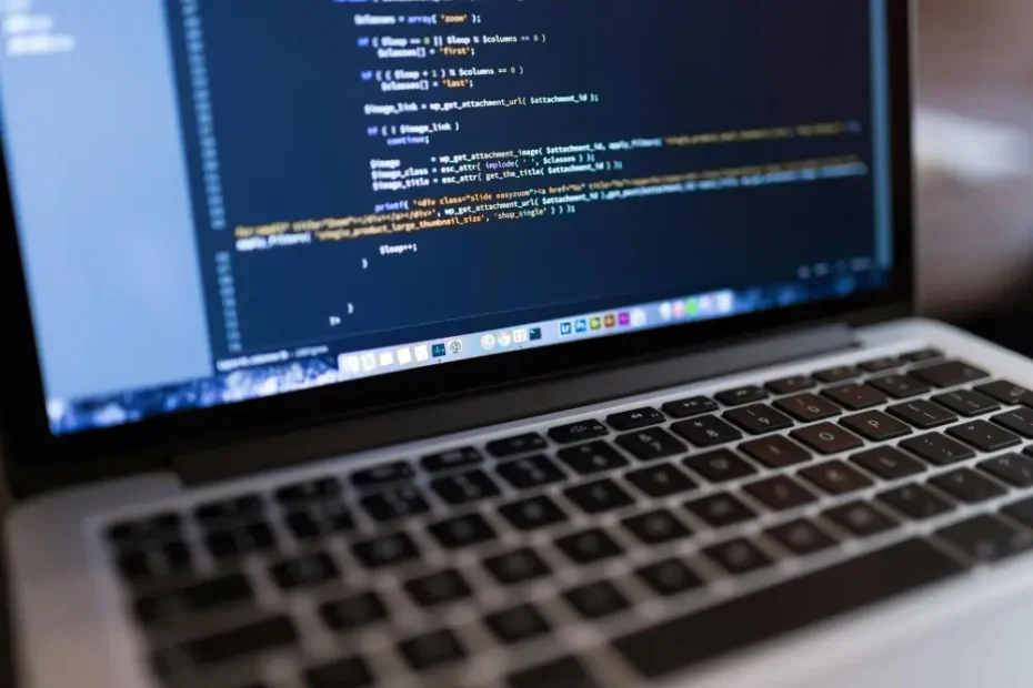 Ordinateur portable affichant du code sur un éditeur, posé sur un bureau
