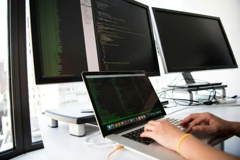 Développeur travaillant sur plusieurs écrans avec du code informatique