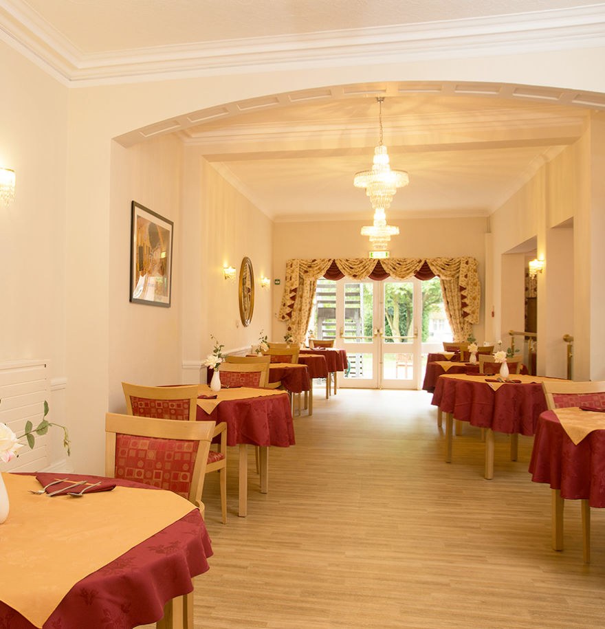 Dining room with chandeliers and red tablecloths