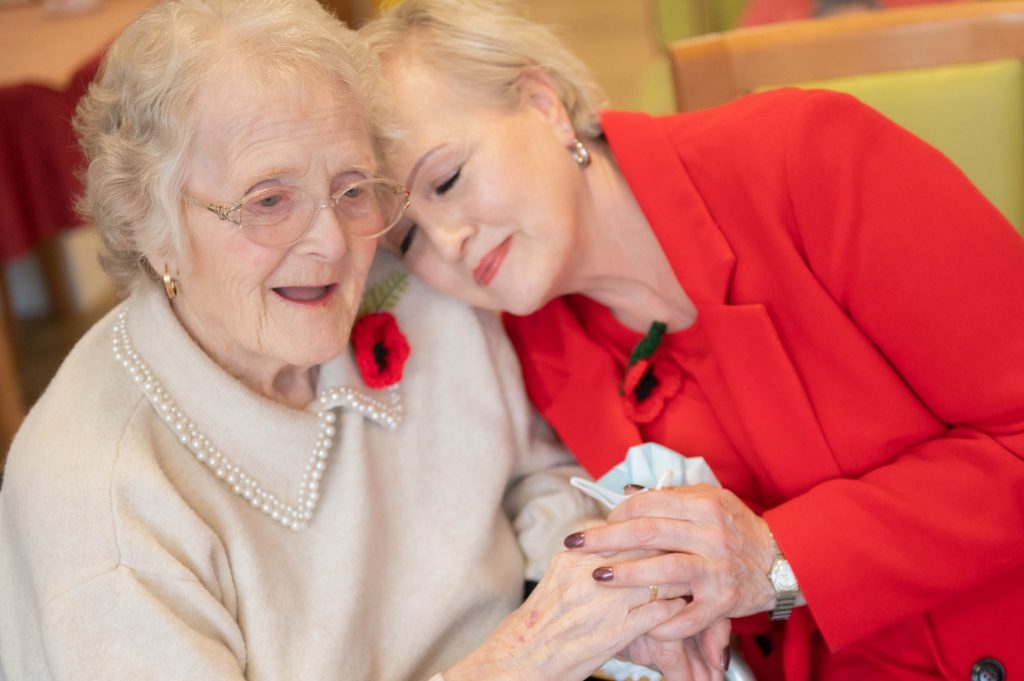 family member and resident hugging and holding hands