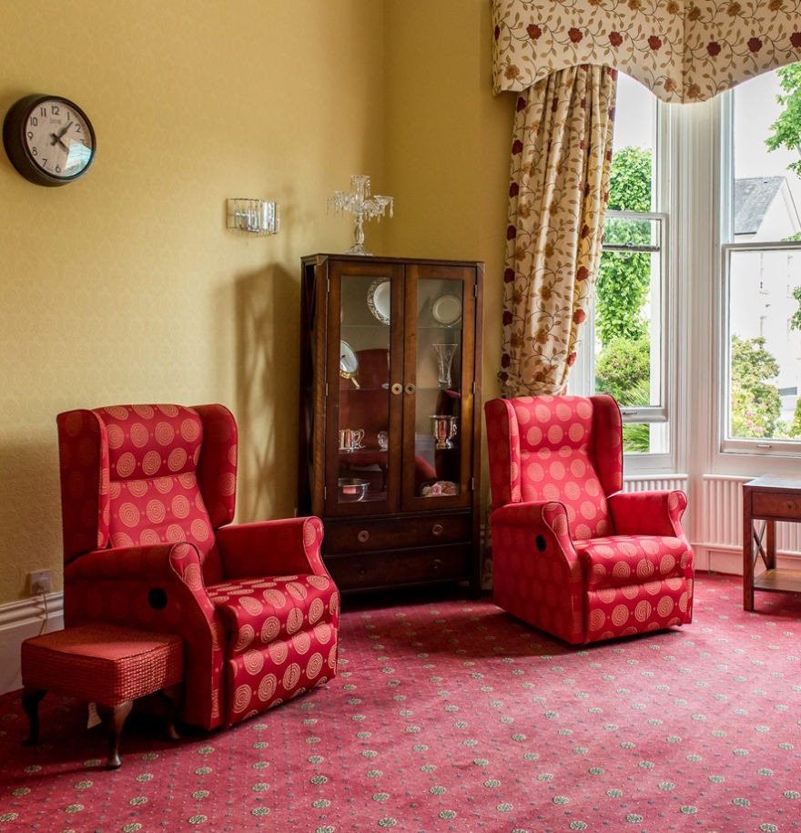 Lounge area with red arm chairs and carpet.