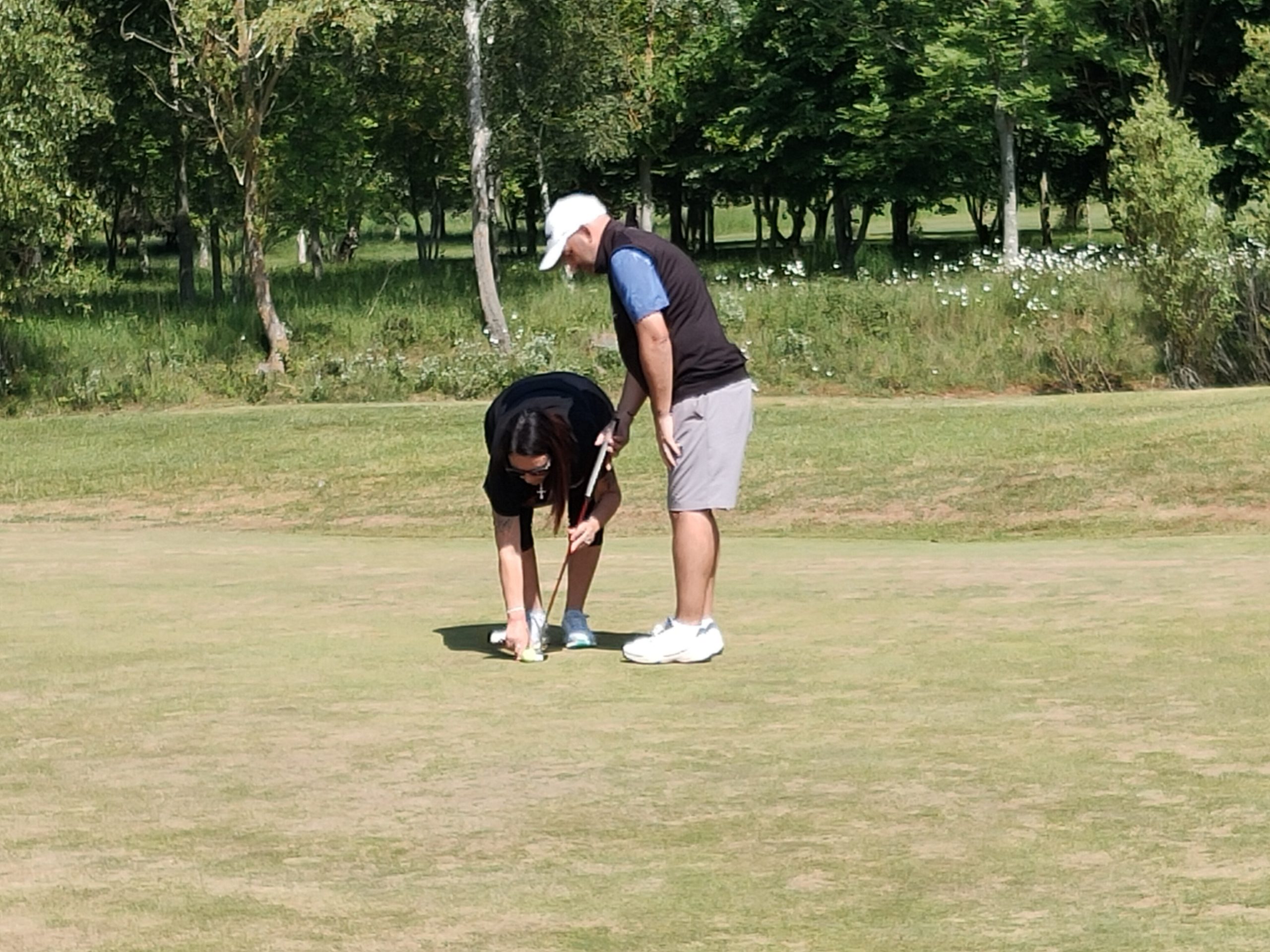 Andy being lined up to putt by his guide and wife Mel