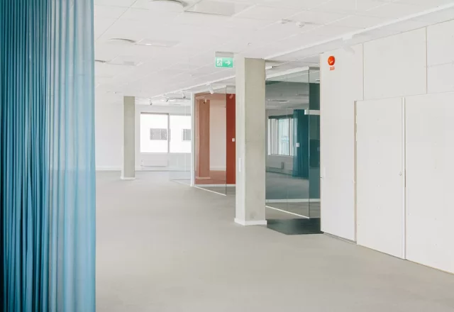 Ljus kontorslokal med blå och röda accentfärger