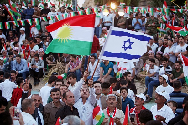 A Kurdish man holds an Israeli and Kurdish flag during a rally to show their support for the upcoming September 25th independence referendum in Erbil