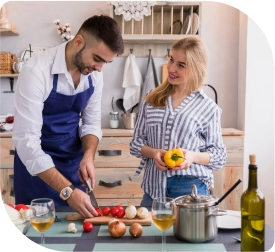 Een stel kookt samen in een keuken, omringd door kookgerei en verse ingrediënten