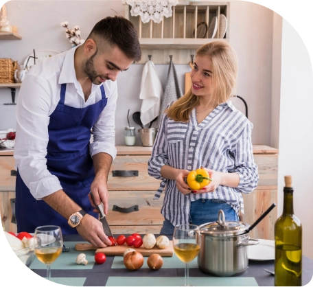 Een stel kookt samen in een keuken, omringd door kookgerei en verse ingrediënten