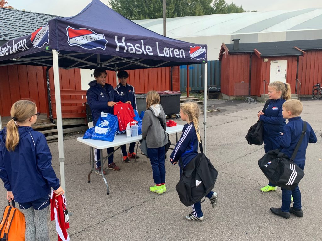 Bildet viser at spillerne på fotballcampen får litt utstyr.