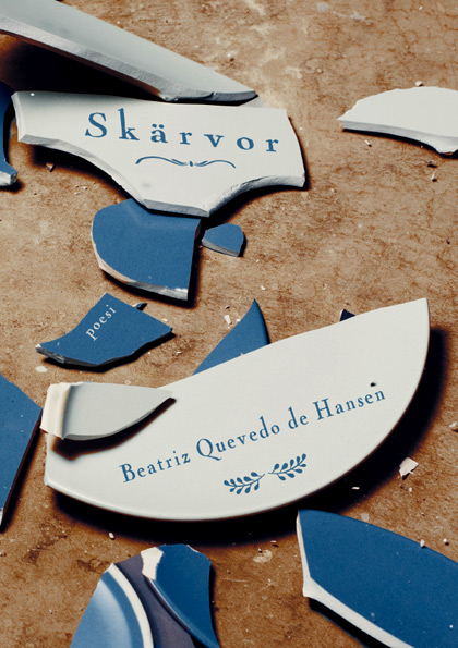 BILD: Omslaget till 'Skärvor' av Beatriz Quevedo de Hansen, på bilden en krossad tallrik i blått porslin på ett brunt golv