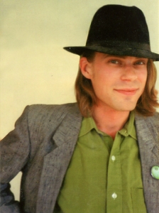 Bild: porträtt av Pontus Tunander iklädd hatt, grön skjorta och kavaj