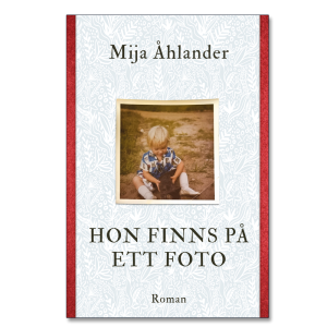 Omslaget till 'Hon finns på ett foto' av Mija Åhlander, vitt med röda kanter och ett foto av ett barn