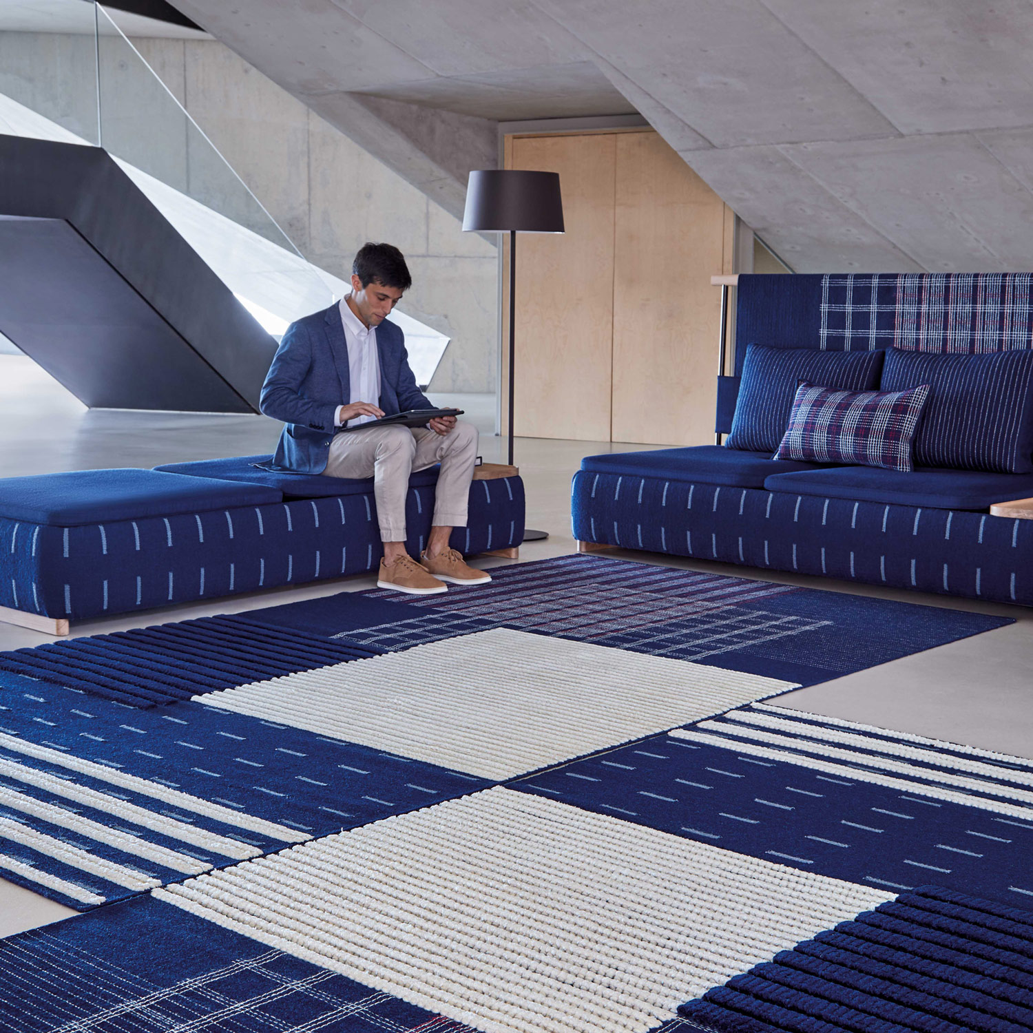 Gulvtæppe i receptionen i indigo blå med sofa og pufs