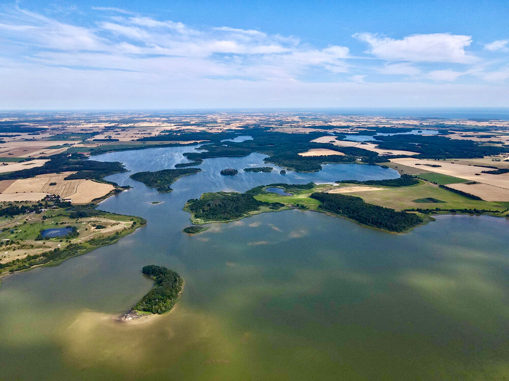 Luftfoto af en fjord på Lolland med små grønne øer