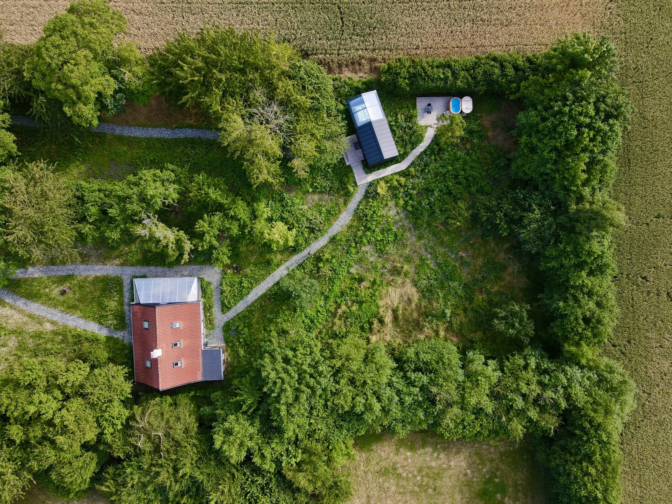 Luftfoto af glashytten omgivet af skov på Lolland