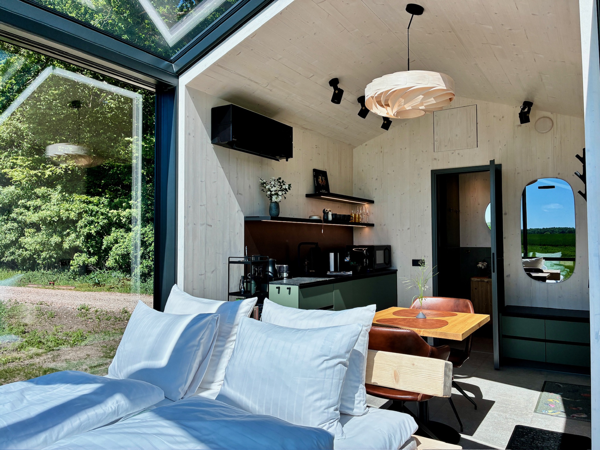Glass Hut Lysa's kitchenette and lounge with forest views through glass walls