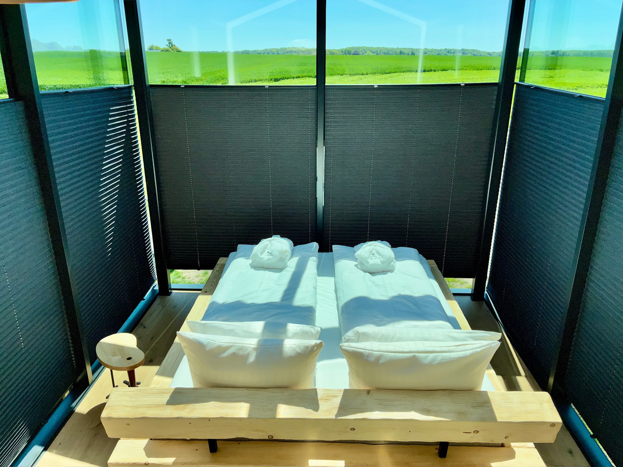 Double bed with pleated privacy blinds inside Glass Hut Lysa