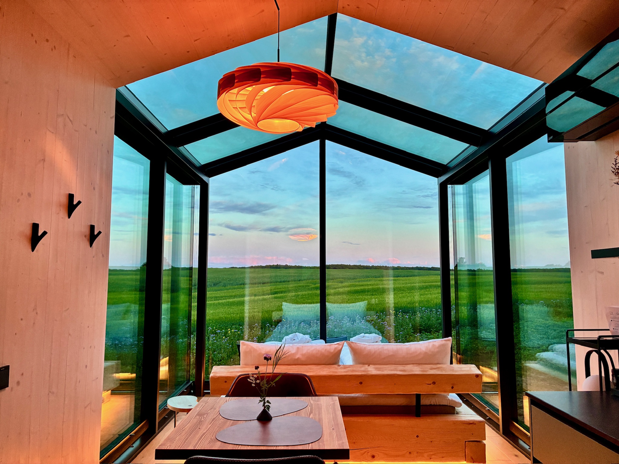 Glass Hut Lysa's dining nook at sunset overlooking open fields