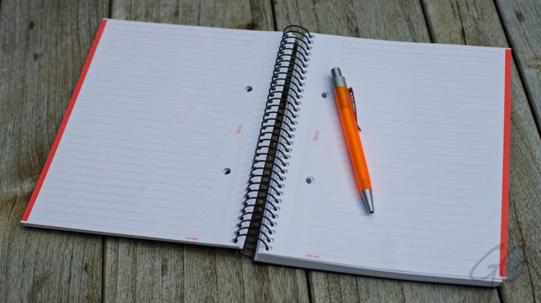 Tekstschrijvers en lezers willen structuur in een verhaal. Foto van notitieblok met pen.