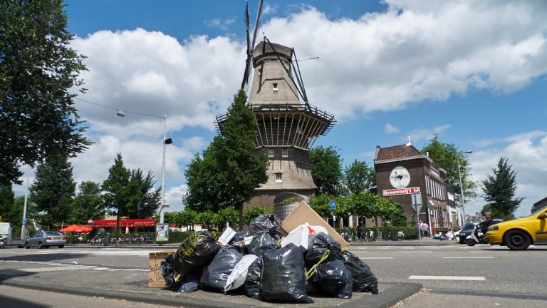 Molen met daarvoor een stapel vuilniszakken