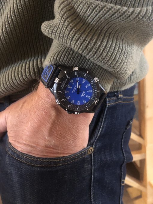 GUL No.1 blue on wrist, blue jeans and green sweater