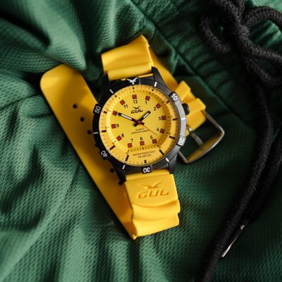 waterproof yellow watch from gul watches on green shorts fabric