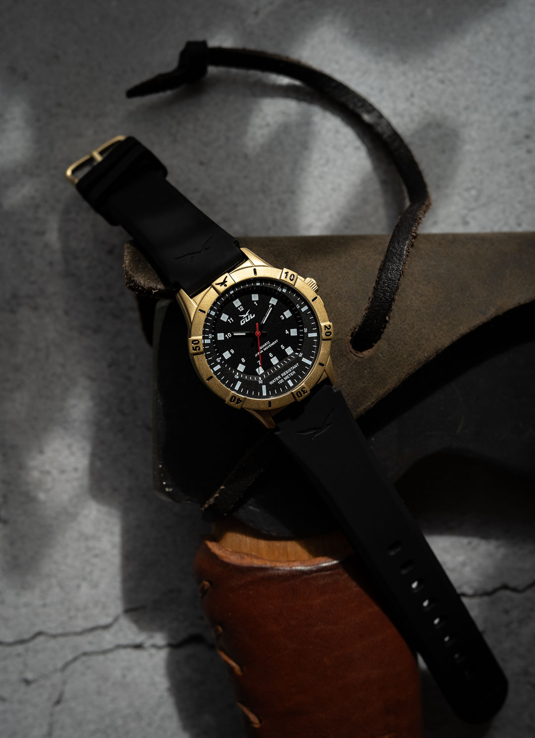 black and gold watch by gul watches laying on an axe