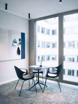 Two tables and a chair in front of a whiteboard