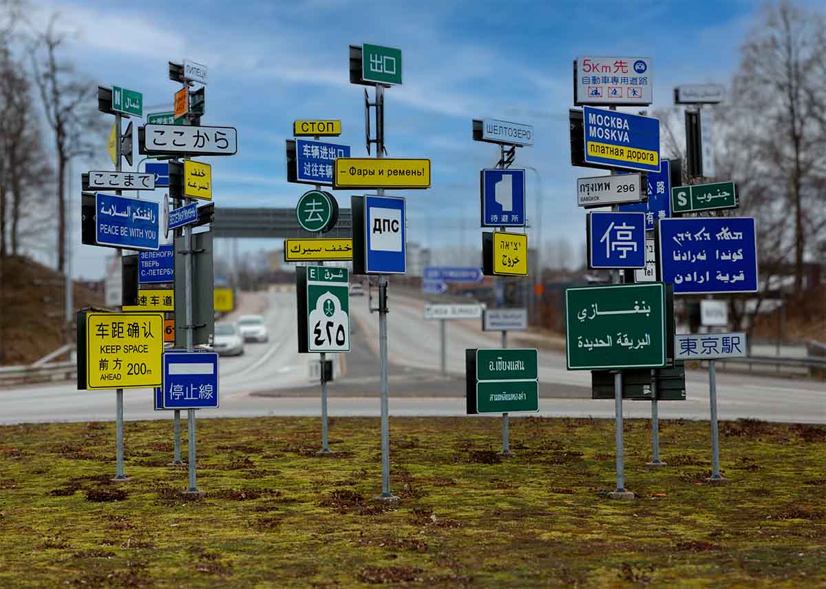 Städfirma i Älmhult visar bild på rondell i Älmhult med trafikskyltar på flera olika språk.
